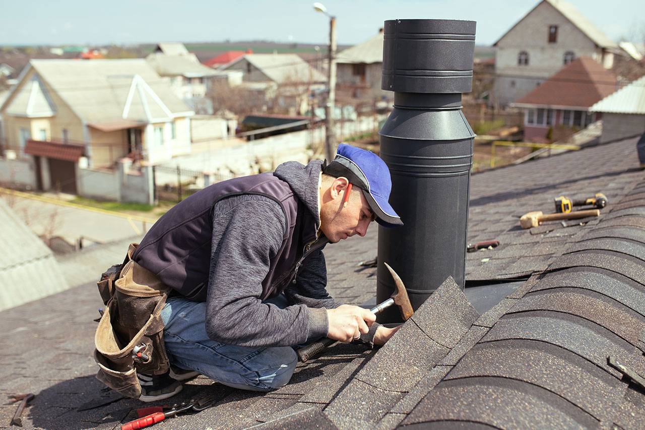 a-professional-master-roofer-with-hammer-repairs-2022-04-25-12-52-41-G9H4KX5